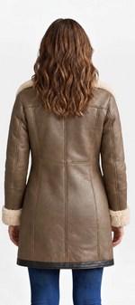 Back view of a woman wearing a Mahaute Hildegarde mid-length brown faux leather coat with cream faux fur trim.