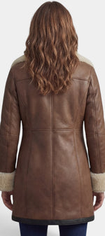 Manteau mi-long en faux cuir marron Mahaute avec col fourré et fermeture zippée, style élégant et moderne.