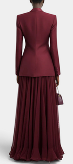 Back view of a Mahaute burgundy two-piece set featuring a structured blazer and a long pleated flowing maxi dress.