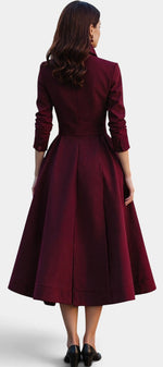 Back view of a Mahaute burgundy midi dress with a structured high collar, cinched waist, and flared skirt.