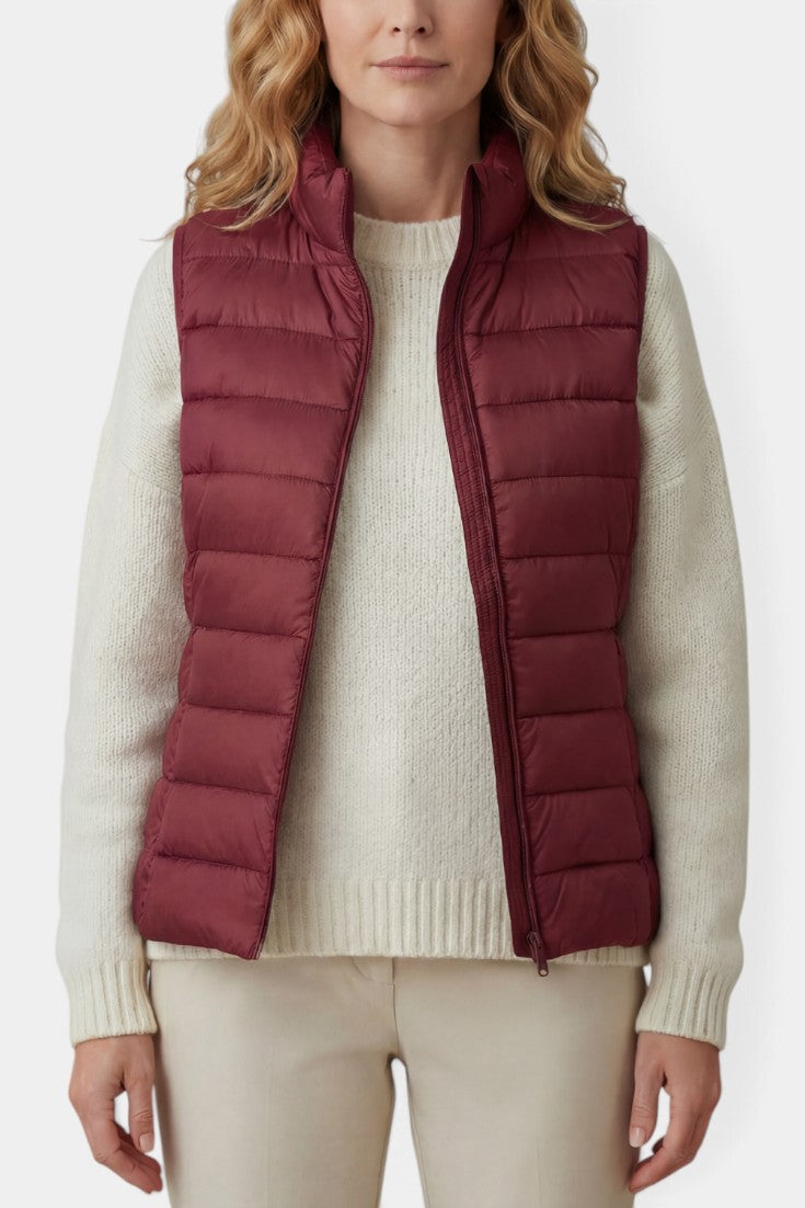 Gilet matelassé mauve Mahaute Caeloria avec col montant et fermeture éclair, porté et visible en détail dans l'image.