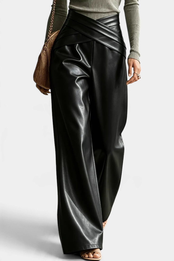 Mahaute Camellia wide-leg trousers in black faux leather with a stylish crossover waistband and front pleats.