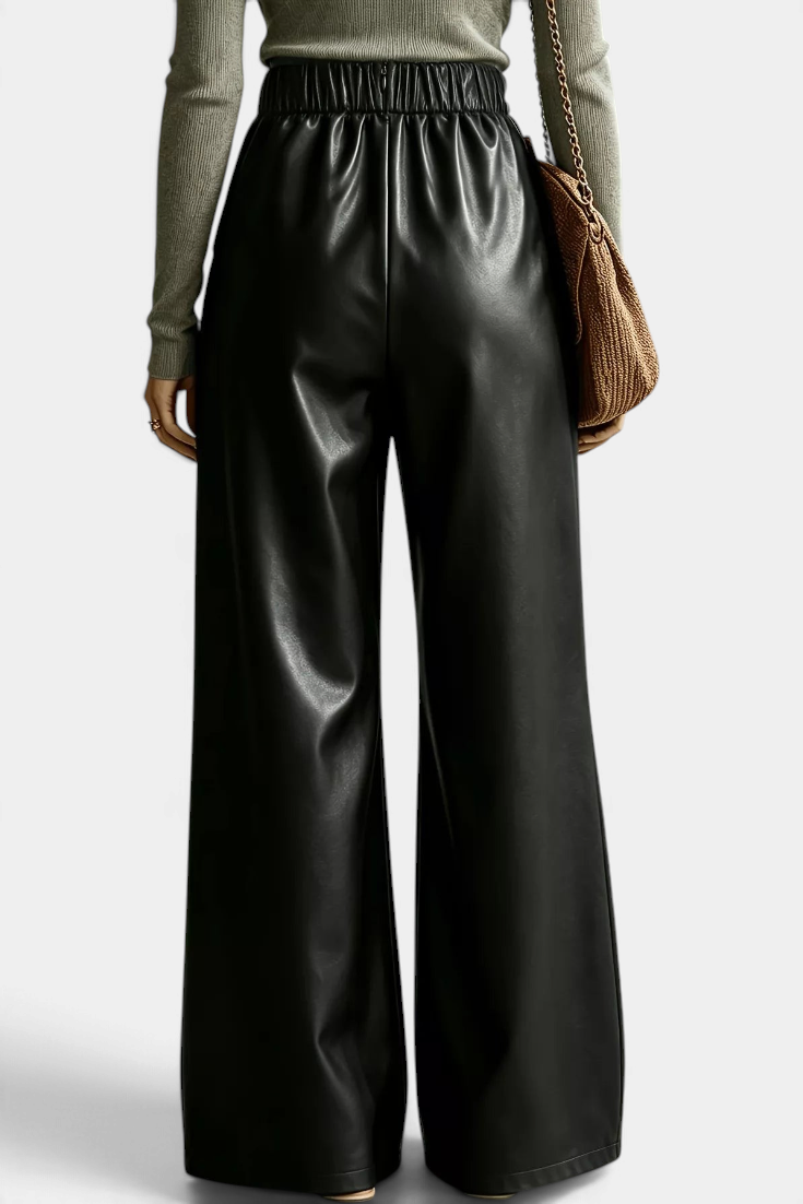 Back view of Mahaute Camellia wide-leg trousers in black faux leather with an elasticated waist