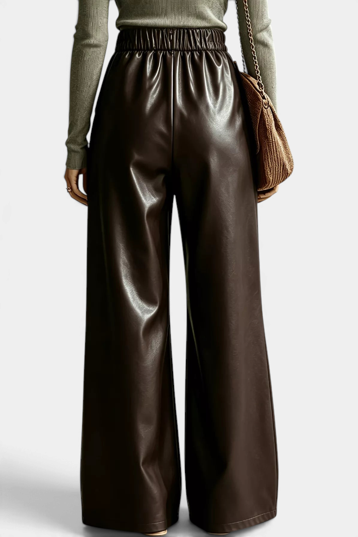 Mahaute Camellia wide-leg trousers in dark brown faux leather with an elasticated waist, back view.