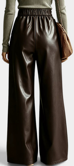 Mahaute Camellia wide-leg trousers in dark brown faux leather with an elasticated waist, back view.