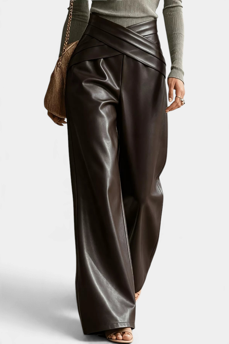 Mahaute Camellia wide-leg trousers in dark brown faux leather with a stylish crossover waist and front pleats.