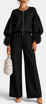 Mahaute Carrie black two-piece set with zip-up top, voluminous puff sleeves, textured cuffs, and wide-leg trousers.