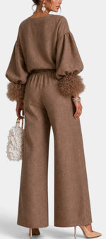 Mahaute Carrie brown two-piece set featuring a zip-up top with puff sleeves, ruffled cuffs, and wide-leg trousers.