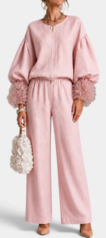 Mahaute Carrie pink two-piece set featuring a zip-up top with voluminous puff sleeves, ruffled cuffs, and wide trousers.