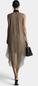 Back view of a model wearing a Mahaute Cecily taupe asymmetrical midi dress with a black lavalliere collar in sheer voile.