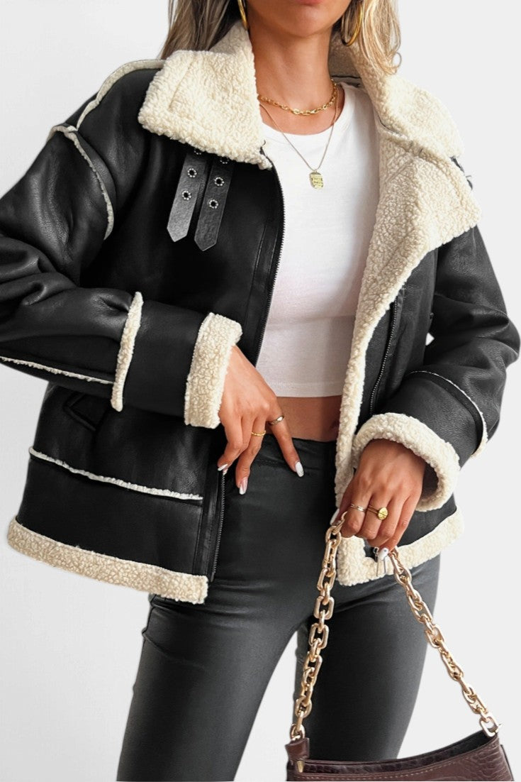 Mahaute Clarimonde black faux leather aviator jacket with cream faux shearling collar, cuffs, and buckled straps.