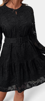Robe courte Mahaute Colaria noire avec motif floral texturé, ceinture et manches transparentes, élégante et moderne.