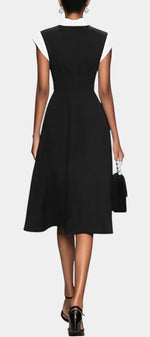Robe mi-longue noire Mahaute Dolores avec col carré, nœud contrasté et manches courtes, élégance moderne pour toutes occasions.