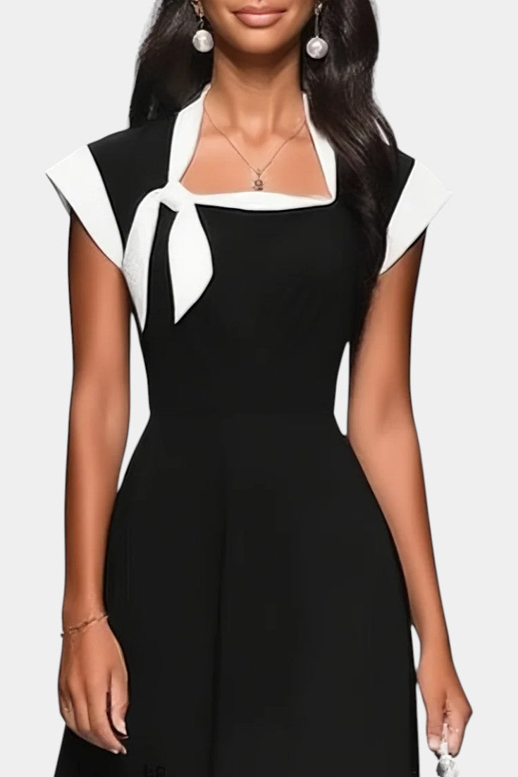 Robe mi-longue Mahaute Dolores à col carré, nœud contrasté, manches courtes, en tissu noir et blanc, élégante et moderne.
