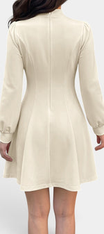 Robe courte Mahaute Edelmira évasée crème avec col montant, découpe goutte et manches longues, style élégant et féminin.