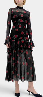 Robe longue Mahaute Églantine à imprimé roses, manches transparentes et volants, élégante et florale, portée sur mannequin.