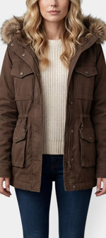 Parka mi-longue Mahaute Eirlys en brun avec capuche en fausse fourrure et taille ajustable, mode hivernale élégante.