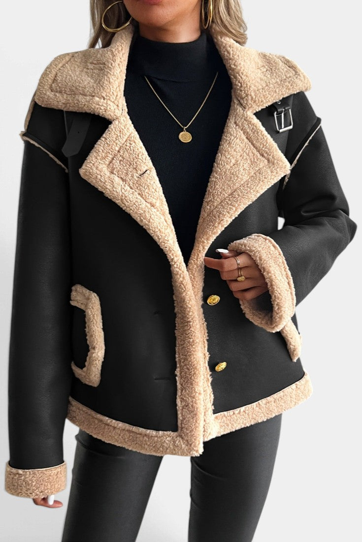 Mahaute Flynn short black faux suede coat with beige faux fur collar, cuffs, and gold buttons worn by a woman.