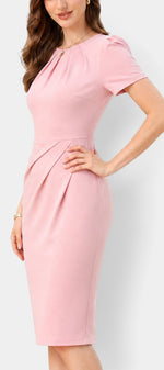 Robe mi-longue ajustée Mahaute Gaudencia rose avec drapé latéral et manches courtes, tissu fluide et élégant.