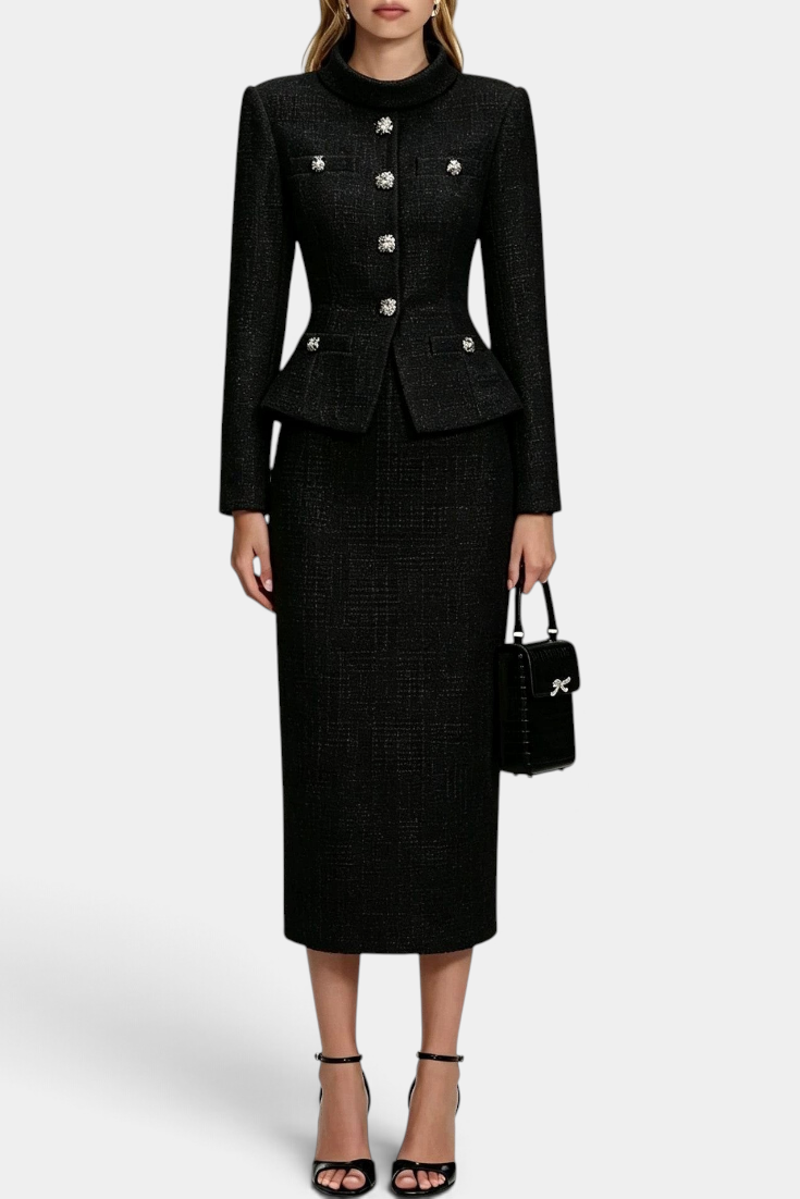 Mahaute Gergana black tweed skirt suit with a structured peplum jacket, jewel buttons, and a midi length skirt.
