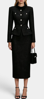 Mahaute Gergana black tweed skirt suit with a structured peplum jacket, jewel buttons, and a midi length skirt.