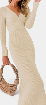 Mahaute Giorgina beige ribbed knit maxi dress with V-neck and twisted bust detail worn with a matching handbag