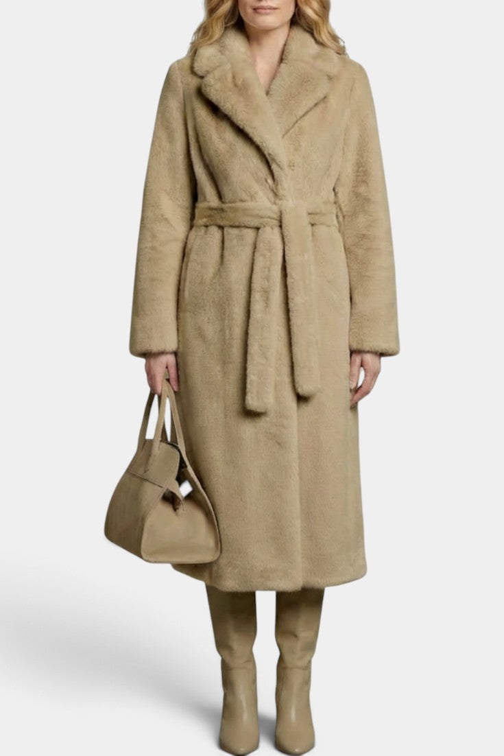 Manteau long beige Haworth Mahaute en fausse fourrure avec ceinture et col tailleur, élégant et chaud, porté sur un fond neutre.