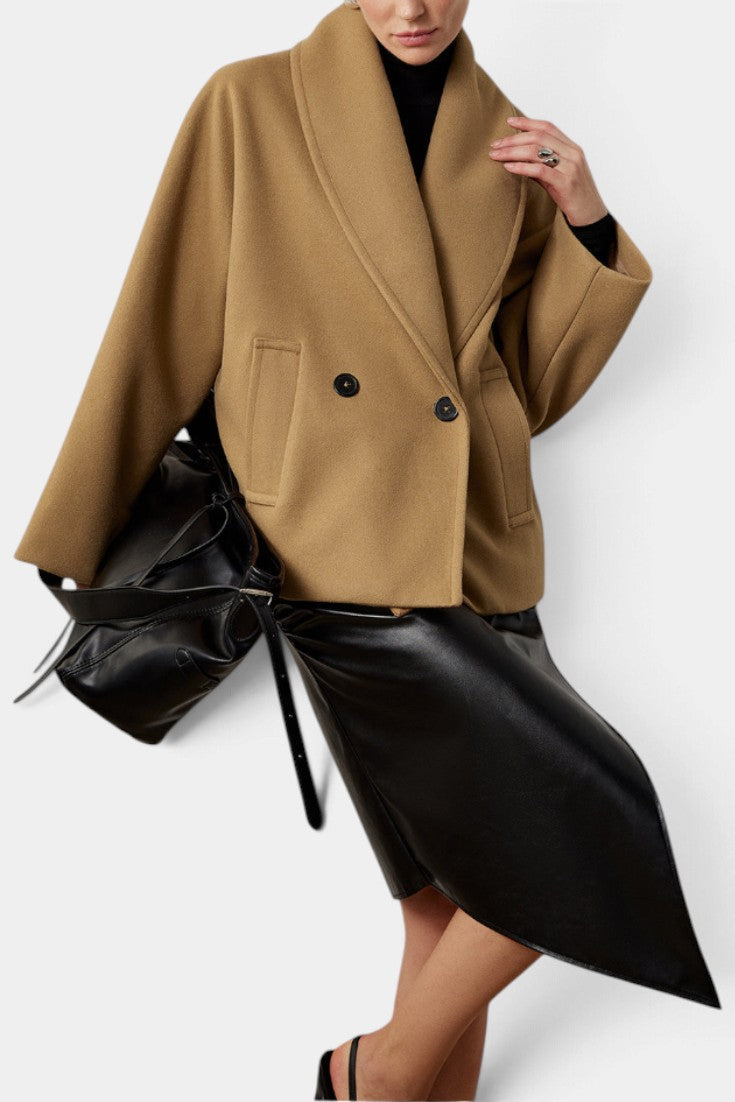 Mahaute Helena camel short coat with shawl collar and double-breasted buttons worn over a black skirt