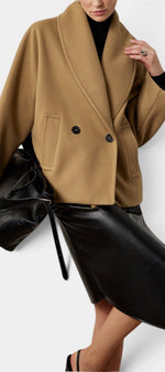 Mahaute Helena camel short coat with shawl collar and double-breasted buttons worn over a black skirt