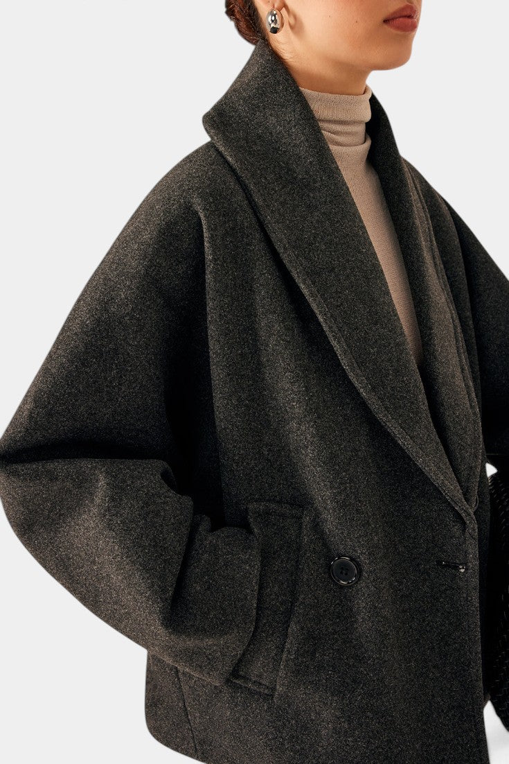 Mahaute Helena charcoal grey short coat with a wide shawl collar and double-breasted design worn over a beige top