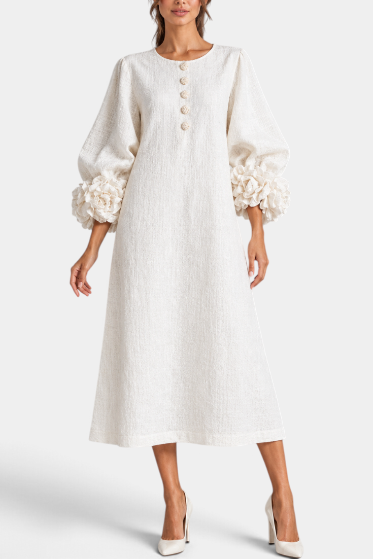 Mahaute Ikavy cream midi dress with puff sleeves, 3D floral cuffs, and decorative buttons.