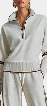 Mahaute Ismay beige knit lounge set with a zip-up mock neck, ribbed cuffs, and brown contrast side stripes.