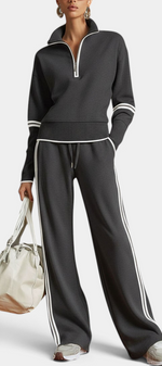 Mahaute Ismay charcoal knit set with zip-up mock neck top and wide-leg trousers featuring white contrast side stripes.