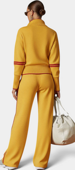 Mahaute Ismay mustard yellow knit set with zip-up collar, ribbed cuffs, and red side stripes on pants and sleeves.