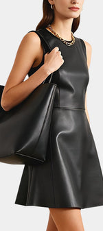 Robe courte évasée en faux cuir noir Isolda par Mahaute, sans manches, style élégant et moderne.