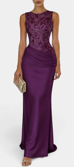 Mahaute Joni long purple satin evening gown with a sleeveless floral embroidered bodice and draped waist detail.