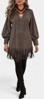 Mahaute Karoly short brown faux suede dress with fringe hem, puff sleeves, and v-neck, styled with high boots.