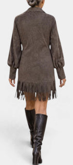 Back view of Mahaute Karoly short brown faux suede dress with puff sleeves and fringe hem worn with tall boots