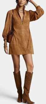 Model wearing Mahaute Karoly short brown faux suede dress with zip collar and puff sleeves, styled with tall boots.