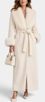 Mahaute Lalie long cream coat with faux fur collar and cuffs, featuring a belted waist on a model with a handbag.