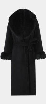 Mahaute Lalie long black coat with a wide faux fur collar and matching faux fur cuffs, featuring a tie waist belt.