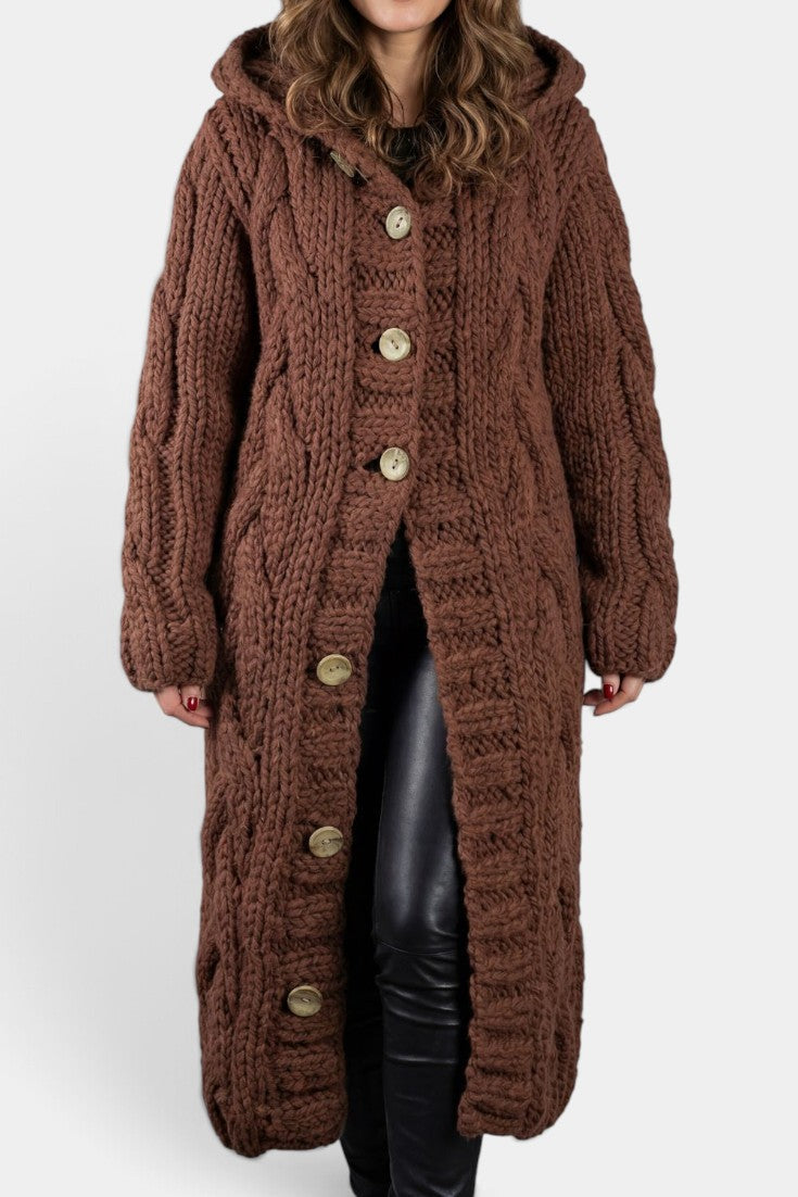 Cardigan long marron en maille torsadée avec capuche et boutons, par Mahaute, porté en image.