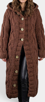 Cardigan long marron en maille torsadée avec capuche et boutons, par Mahaute, porté en image.