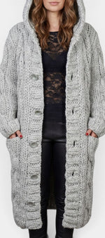 Cardigan long gris en maille torsadée avec capuche et boutons, par Mahaute, vêtement chaud et confortable pour l'hiver.