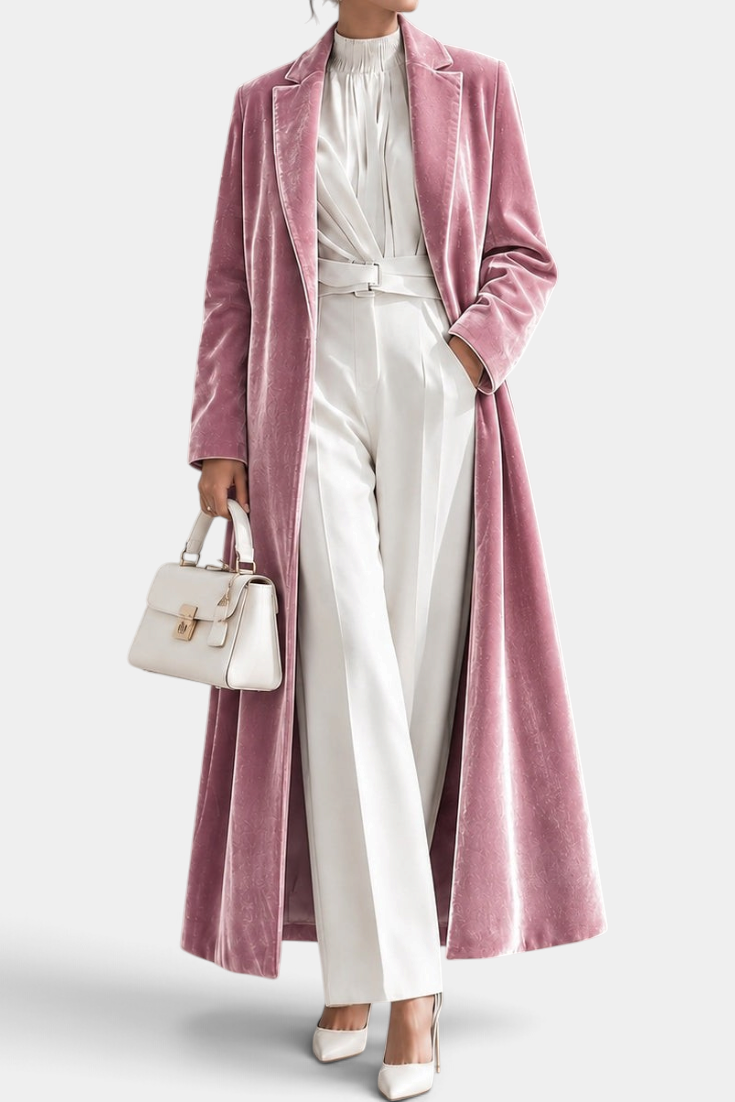 Mahaute long pink velvet coat with elegant lapels, worn over a white outfit with a matching handbag.