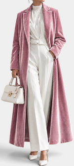 Mahaute long pink velvet coat with elegant lapels, worn over a white outfit with a matching handbag.