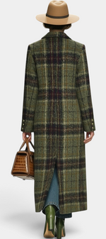 Back view of a model wearing a Mahaute long structured plaid coat in olive green with a brown hat and handbag.