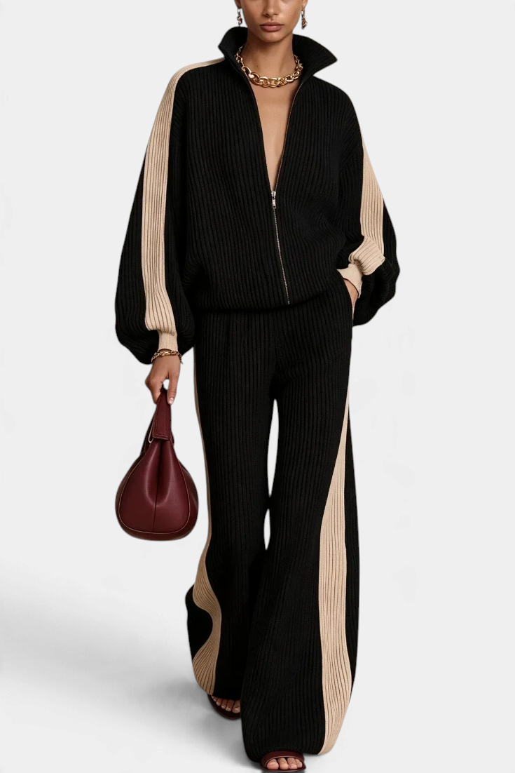 Model wearing Mahaute Luella black ribbed knit zip-up jacket and wide-leg trousers with beige contrast side stripes.