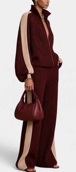 Mahaute Luella ribbed knit set in burgundy with beige contrast side stripes, featuring a zip-up jacket and wide pants.