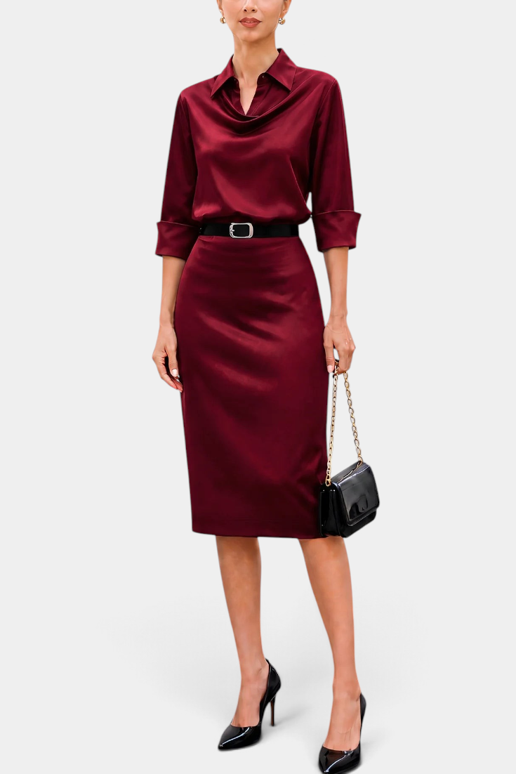 Mahaute Macarena midi dress in burgundy satin with a shirt collar, draped bodice, and a square buckle belt.